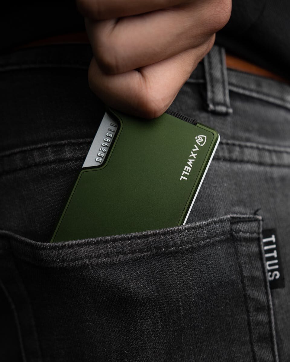 Green metal wallet fits stylishly in a back denim pocket, ideal for modern minimalists.