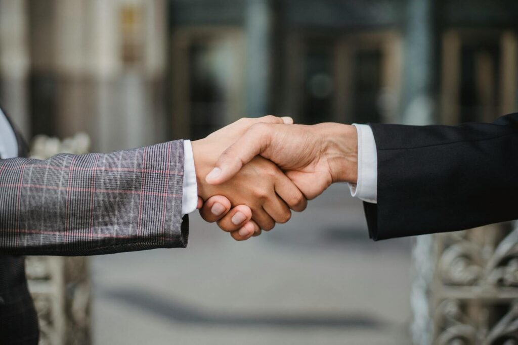 A close-up of two businesspeople shaking hands, symbolizing cooperation and partnership.