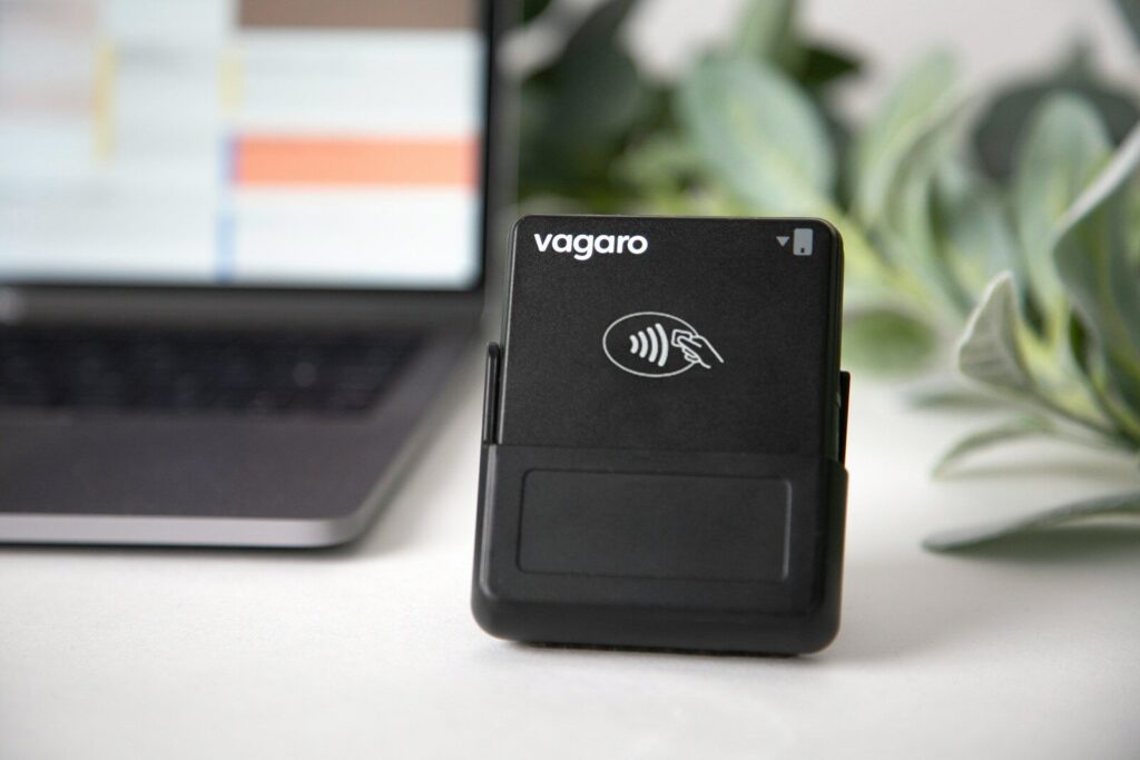 A vagaro card reader sits next to a laptop.