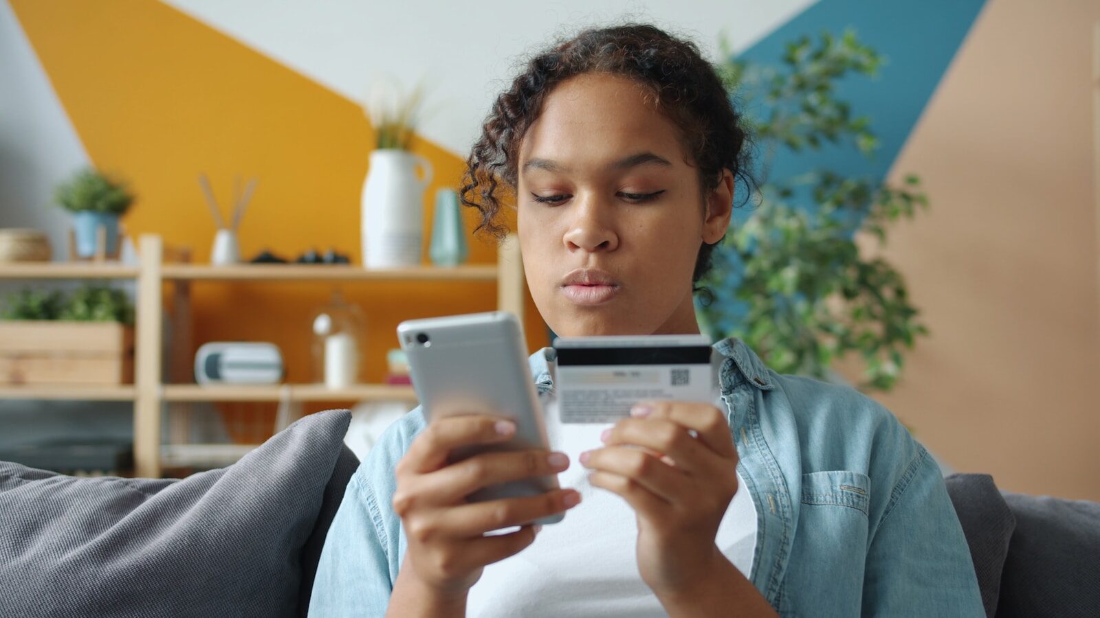 Woman holding credit card and phone for online shopping
