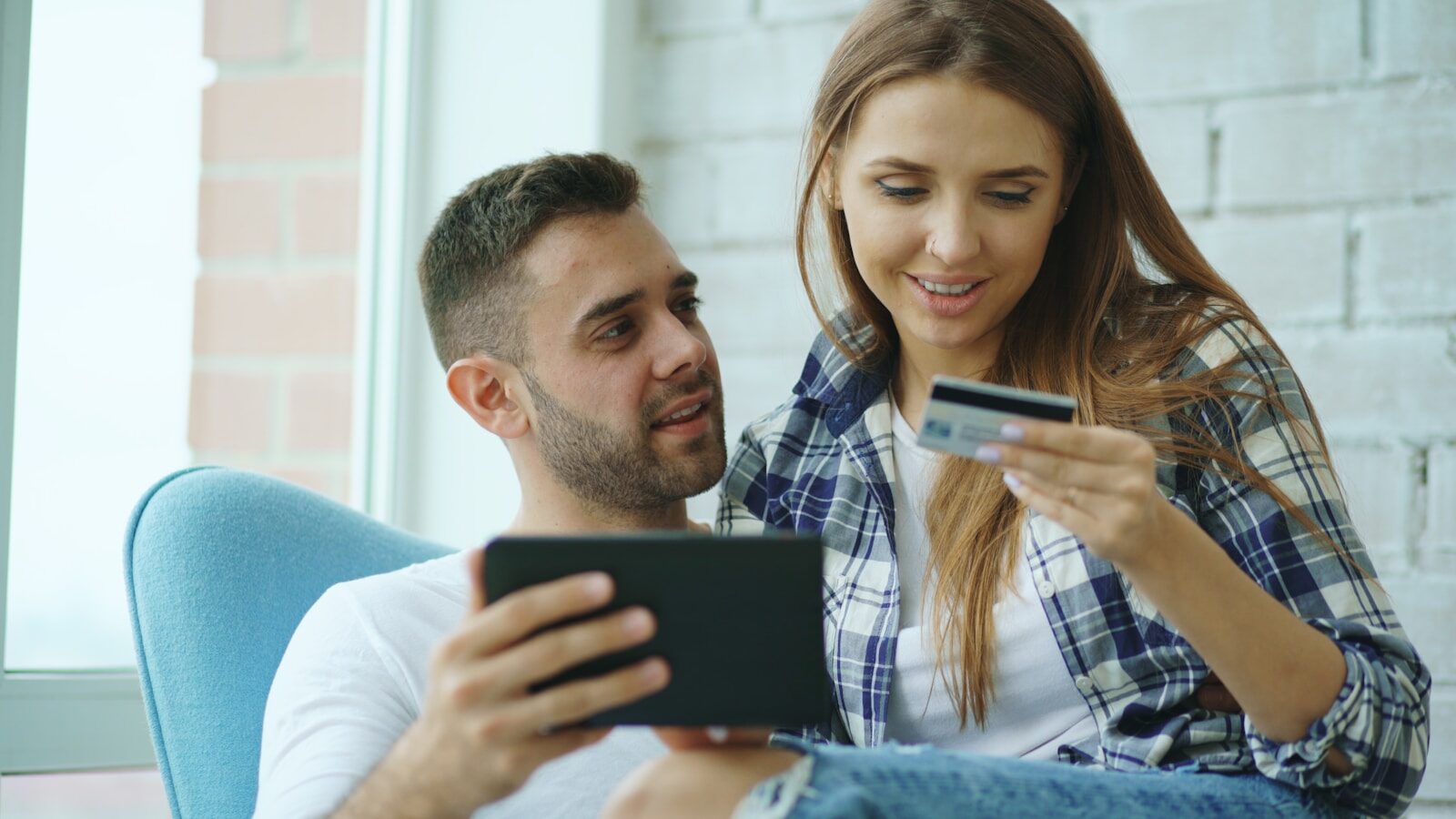 Couple using tablet and credit card for online shopping