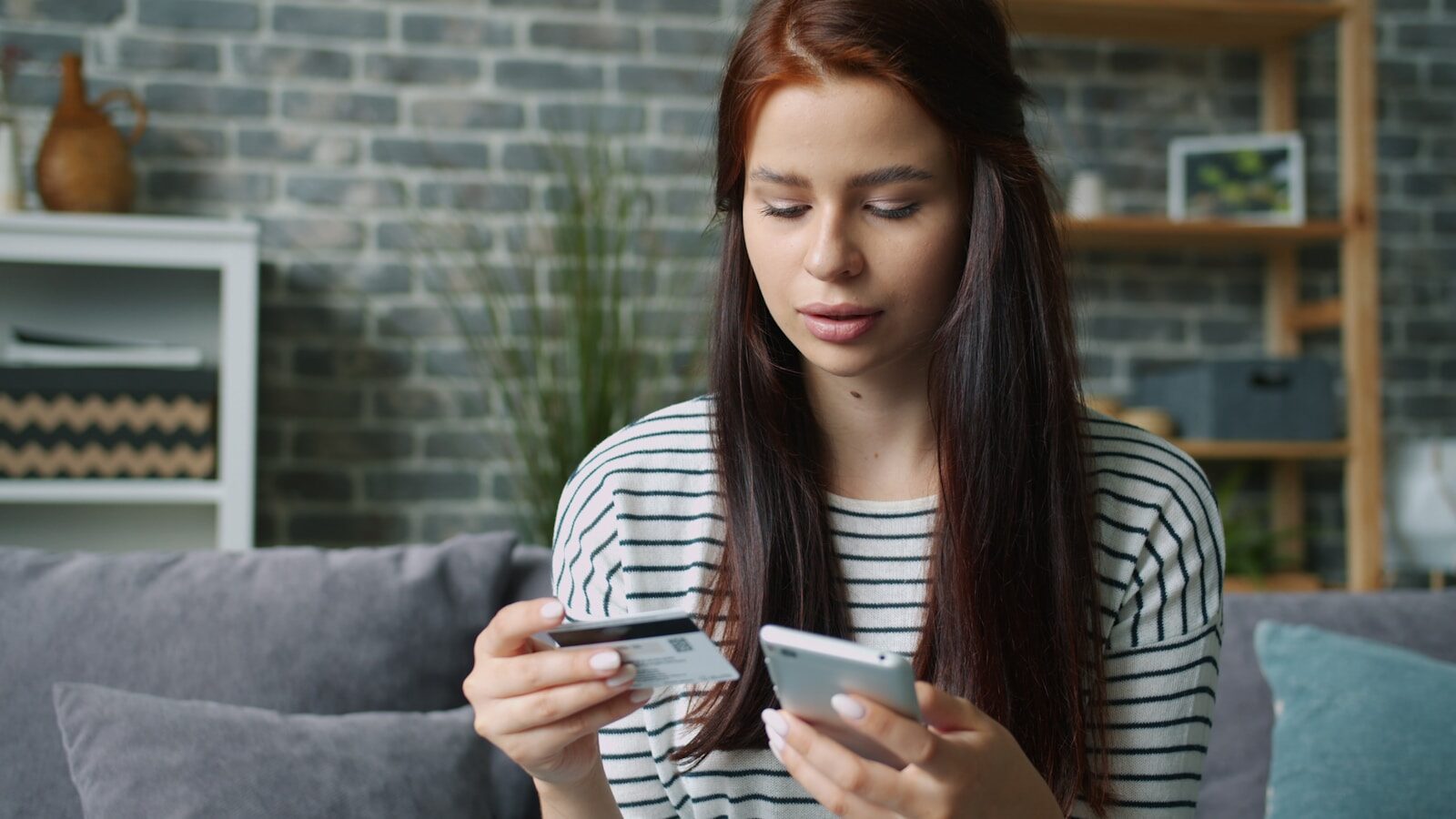 Woman holding credit card and smartphone for online shopping