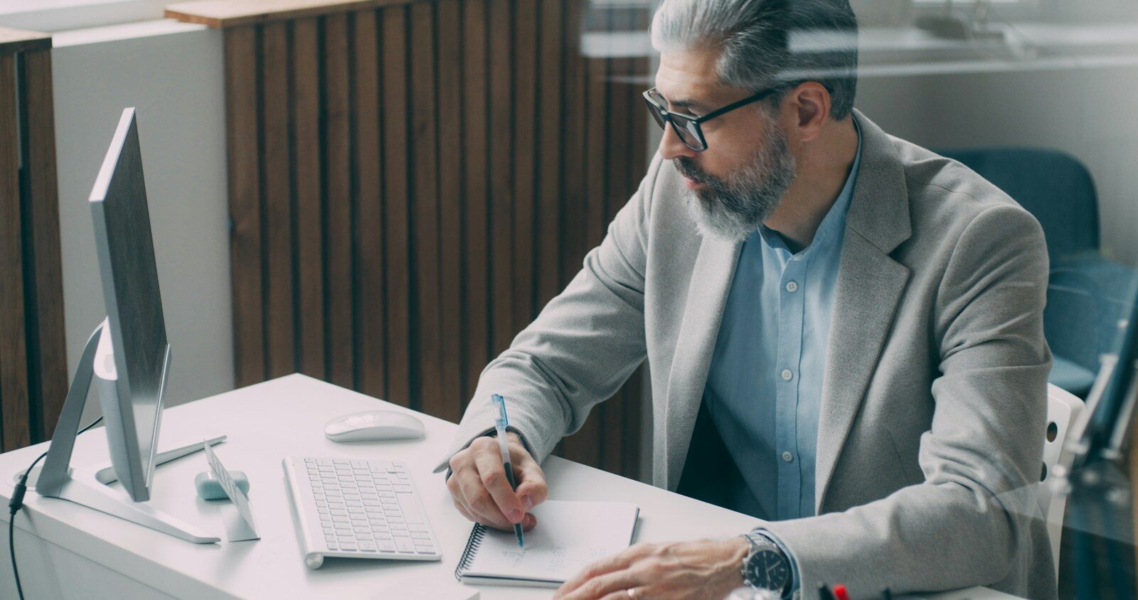A man sitting at a desk writing on a piece of paper